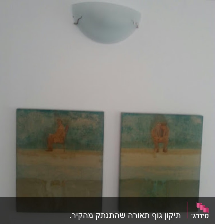 שני ציורים על קיר עם מנורה מעליהם